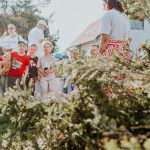 Children and adults participating in an outdoor educational activity surrounded by nature.