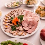 A beautifully arranged table with a variety of meats, fruits, and cheeses.